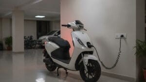 Electric scooter plugged in for home charging at an Indian apartment parking area
