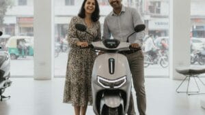 Indian couple at an electric scooter dealership benefiting from the PM E-Drive subsidy scheme