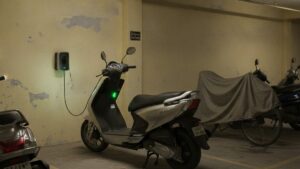 Electric scooter charging at home in an Indian apartment building parking area