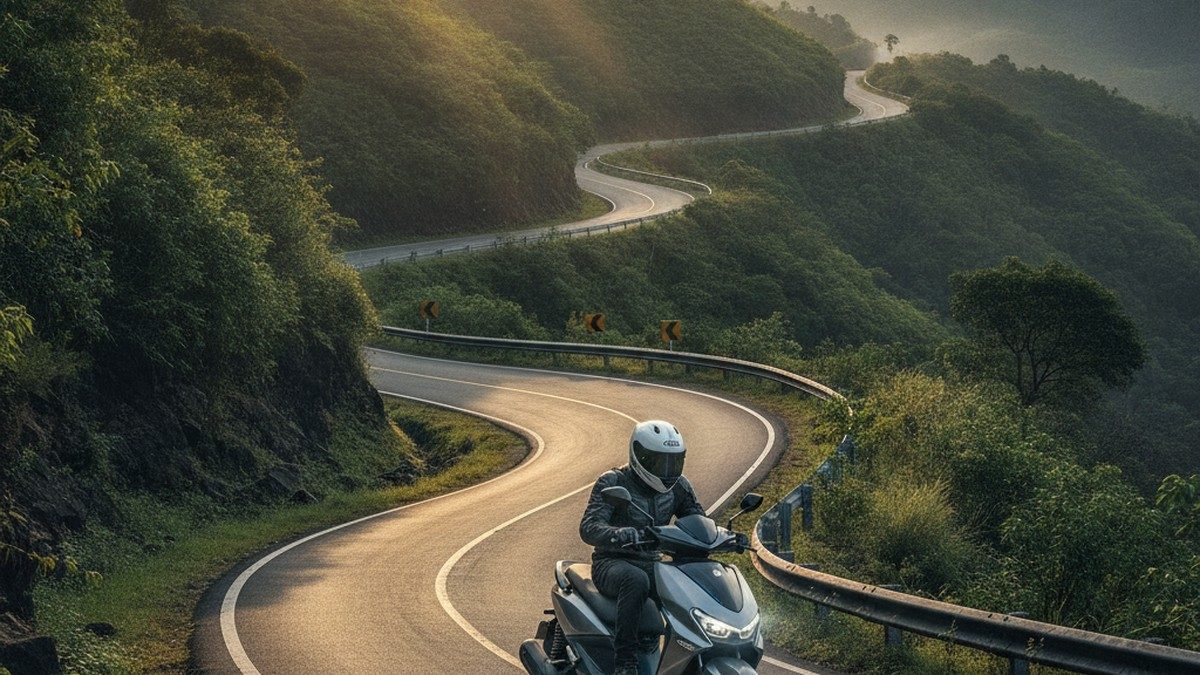 Electric scooter riding up a winding ghat road in India with green hills